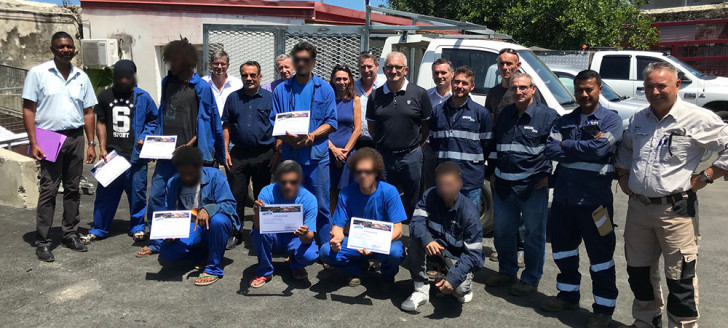 Photo de famille, diplôme à la main, devant la camionnette des services techniques dont les stagiaires ont réalisé la galerie.